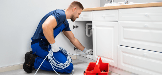 plumber working under sink